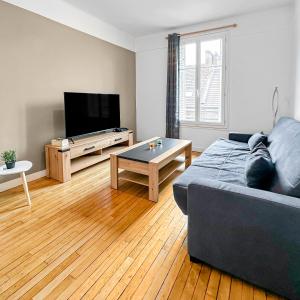 ein Wohnzimmer mit einem Sofa und einem Tisch in der Unterkunft Élégant Pied-à-Terre à Beauvais in Beauvais