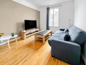 ein Wohnzimmer mit einem Sofa und einem Tisch in der Unterkunft Élégant Pied-à-Terre à Beauvais in Beauvais