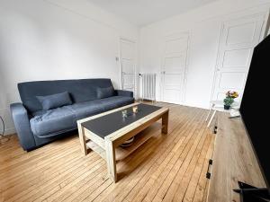 ein Wohnzimmer mit einem blauen Sofa und einem Couchtisch in der Unterkunft Élégant Pied-à-Terre à Beauvais in Beauvais