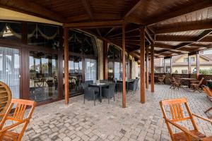 un patio al aire libre con sillas, mesas y ventanas en Hotel Amalia, en Starý Smokovec