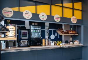 une cuisine avec un comptoir avec des panneaux sur le mur dans l'établissement B&B HOTEL Grenoble Centre Verlaine, à Grenoble