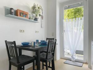 een eetkamer met een tafel en stoelen en een raam bij Gemütliches Apartment, Seenähe, WM, WLAN, Balkon in Markkleeberg