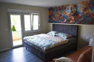 a bedroom with a bed with a painting on the wall at Boutique Hotel PHOENIX Međugorje in Međugorje