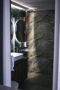 a bathroom with a sink and a wall with a leaf pattern at Boutique Hotel PHOENIX Međugorje in Međugorje