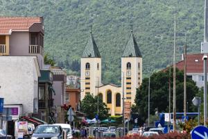 a town with two towers with clocks on its buildings at Boutique Hotel PHOENIX Međugorje in Međugorje