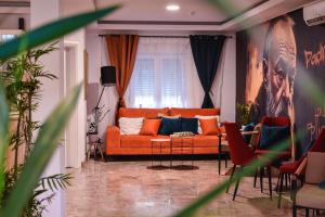 a living room with an orange couch and chairs at Boutique Hotel PHOENIX Međugorje in Međugorje