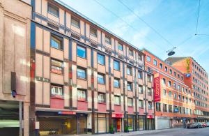 ein großes Gebäude an einer Stadtstraße mit in der Unterkunft Leonardo Hotel München City Center in München