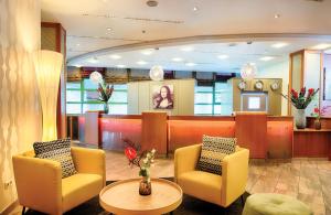 a lobby with two chairs and a waiting room at Leonardo Hotel Mannheim City Center in Mannheim