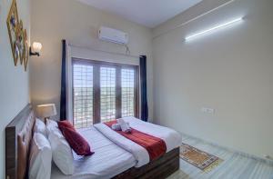 - une chambre avec un grand lit et une fenêtre dans l'établissement TAJ VILLA Mahabaleshwar, à Mahabaleshwar