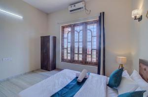 - une chambre avec un grand lit et une fenêtre dans l'établissement TAJ VILLA Mahabaleshwar, à Mahabaleshwar