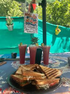 een tafel met een bord toast en drankjes bij Tiny Spot Hostel in Manāli