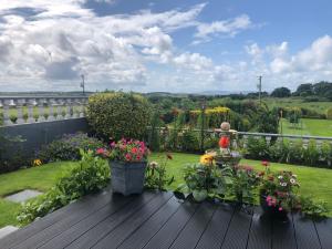 a garden with flowers on a wooden deck at Seacrest in Galway