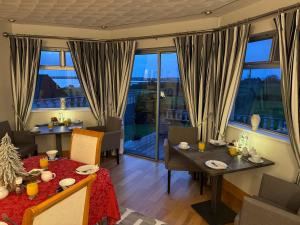 a dining room with a table and chairs and windows at Seacrest in Galway