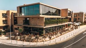 a building with a balcony with tables and chairs at M Boutique Hotel - Designed for Adults in Paphos City