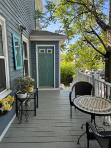 un portico con porta verde, tavolo e sedie di Beautiful Victorian house, Room a Boston