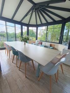 une salle à manger avec une table et des chaises blanches dans l'établissement Gite "Chez Eléonore et Axel", à Gouvieux