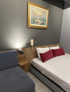 een slaapkamer met een bed met 2 rode kussens bij VILLA CABARE Apartments&Rooms in Durrës