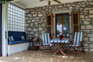 eine Veranda mit Stühlen, einem Tisch und einem Fenster in der Unterkunft Apartment Derossi in Umag