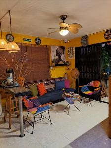 een woonkamer met een blauwe bank en stoelen bij Hostel Shalom Adonai in Cartagena