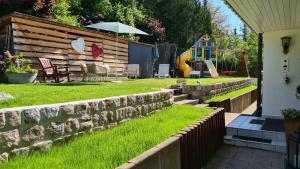 a backyard with a retaining wall and a playground at 'Tor zum Schwarzwald' Ferienwohnungen in Wildberg