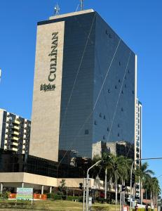 un edificio alto con un cartel en el costado en Cullinan - Fabuloso apt da REDE PREMIUM 13º andar, en Brasilia