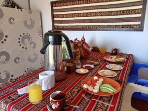 a table with a coffee pot and plates of food at Q'OTA TAYPY LODGE in Puno