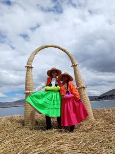 two women standing under an arch in a field at Q'OTA TAYPY LODGE in Puno