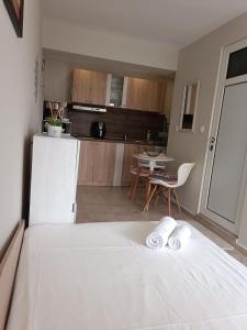 Cet appartement comprend une chambre avec un lit blanc et une cuisine. dans l'établissement Megi Apartments, Nesebar sity, à Nessebar