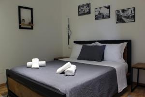 een slaapkamer met een bed met twee handdoeken erop bij Guest House AmaDes in Gjirokastër