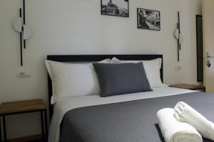 een slaapkamer met een bed met twee foto's aan de muur bij Guest House AmaDes in Gjirokastër