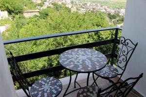 een balkon met een tafel en stoelen bij Guest House AmaDes in Gjirokastër