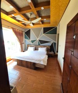 a bedroom with a large bed and a ceiling at Roof Top Resort in Murree