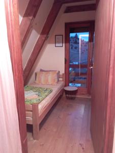 Habitación pequeña con cama y ventana en Rooms Apartment Durmitor, en Žabljak