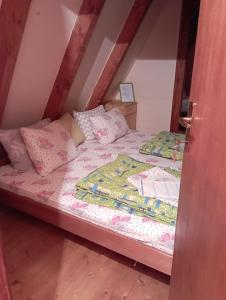 1 dormitorio con 1 cama con sábanas y almohadas rosas en Rooms Apartment Durmitor, en Žabljak