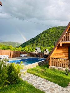 una casa con una piscina y un arco iris en el fondo en Eco House Borjomi, en Borjomi