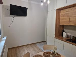 cocina con mesa y TV en la pared en Nad Brzegiem, en Mrągowo