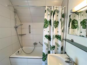 een badkamer met een douchegordijn, een wastafel en een bad bij Apartment Wichtelmännchen by Interhome in Dittishausen