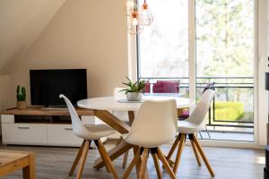 een eetkamer met een witte tafel en stoelen bij Strandhaus 2 OG in Röbel