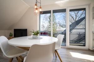 een witte eetkamer met een witte tafel en witte stoelen bij Strandhaus 2 OG in Röbel