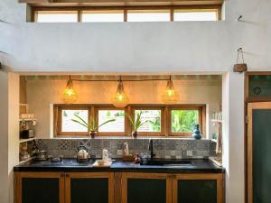 een keuken met een wastafel en 2 ramen bij Iron Rose Villa with garden & pool Kuta Lombok in Kuta Lombok