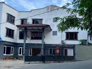 Uma casa branca com um portão à frente. em RedDoorz at Hotel Ermashta Jayapura em Jayapura