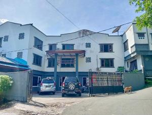 um edifício branco com um carro estacionado em frente em RedDoorz at Hotel Ermashta Jayapura em Jayapura