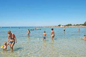 a group of people in the water at the beach at Mobile homes in Zaton Holiday Resort, with large pool area in Zaton