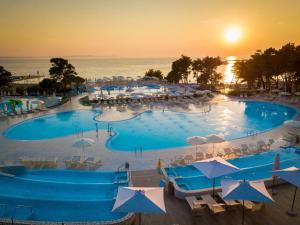 a large swimming pool with umbrellas and the ocean at Mobile homes in Zaton Holiday Resort, with large pool area in Zaton