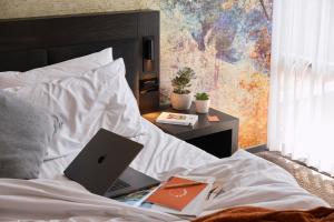 einen Laptop auf einem Bett in der Unterkunft Kennigo Hotel Brisbane, Independent Collection by EVT in Brisbane