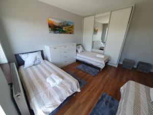 a small bedroom with two beds and a mirror at Apartament nr 1 Chorzelów in Mielec