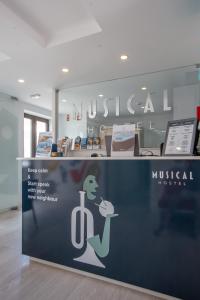 een bord voor een museum met een vrouw die een boek vasthoudt bij Musical Hostel in Albufeira