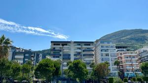 a large apartment building in front of a mountain at Luxury Sea View Apartment in Vlorë