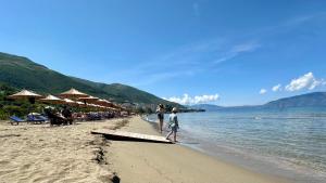 a couple of people walking on the beach at Luxury Sea View Apartment in Vlorë