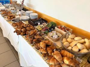 um buffet de pão e produtos de pastelaria numa mesa em Art & Hotel Treviolo em Treviolo